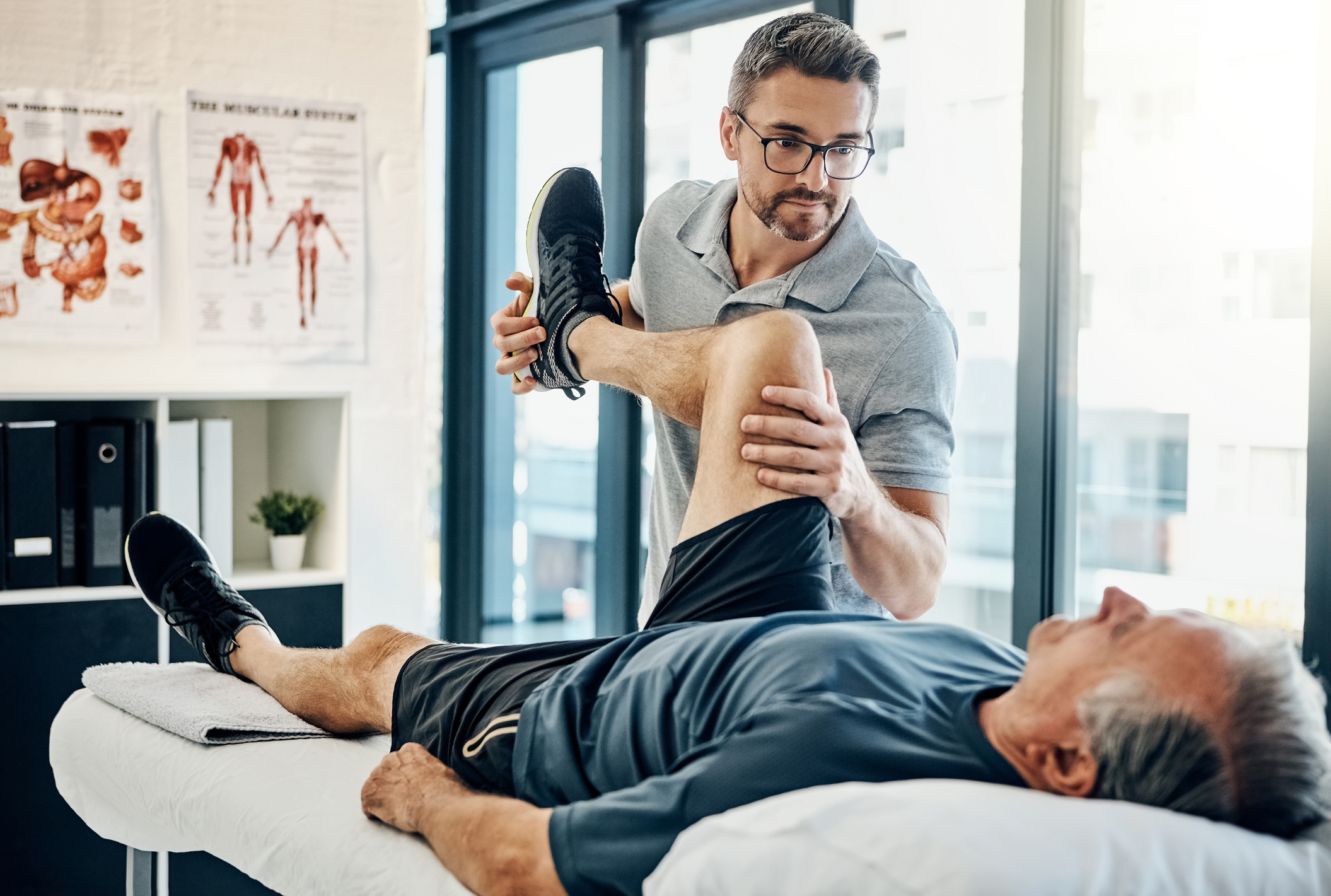 Shot of a friendly physiotherapist treating his mature patient in a rehabilitation center to help him in recovery